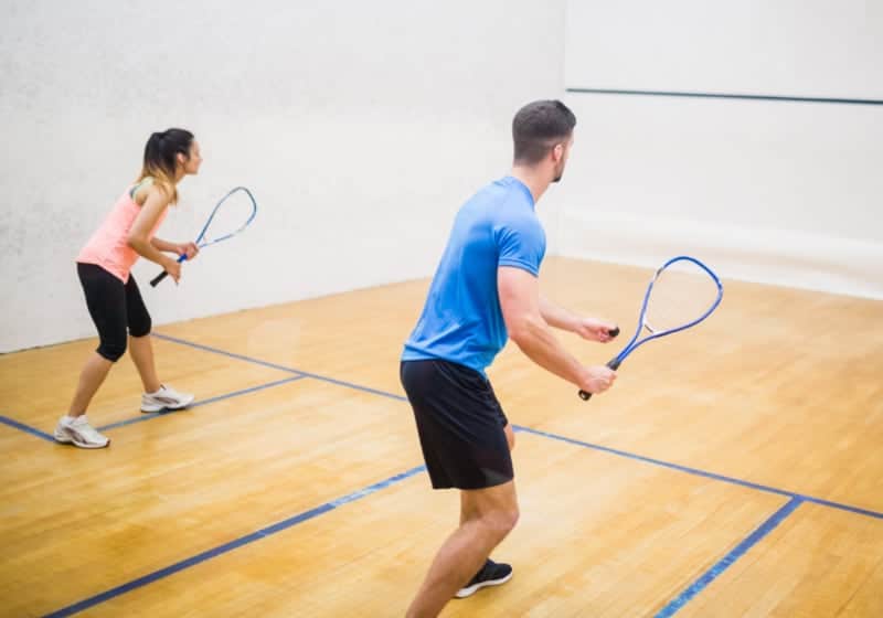 Couple playing Squash indoors.